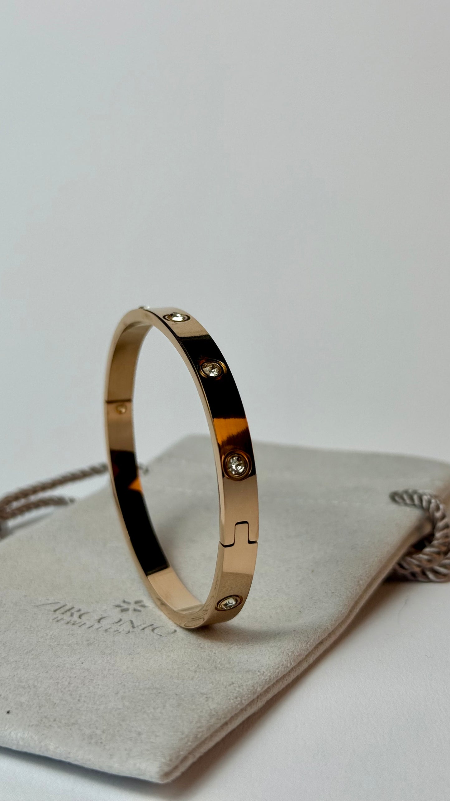 Gold bracelet with diamonds on a light gray surface