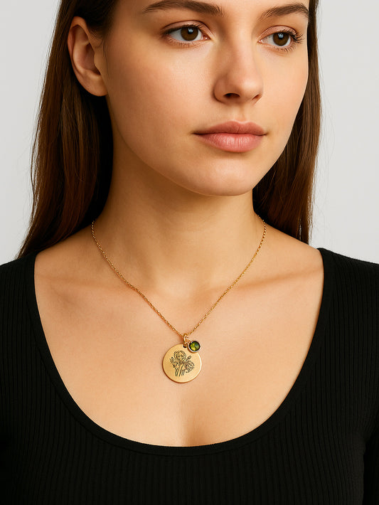 Woman wearing a gold necklace with a pendant on a plain background