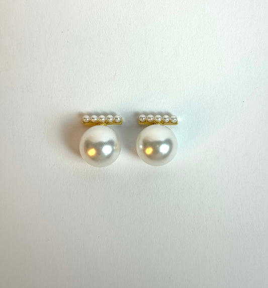 Pair of pearl earrings with gold accents on a white background