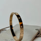 Gold bracelet with diamonds on a light gray surface