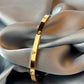 Gold bracelet on a gray fabric background