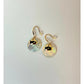 Gold earrings with round, light-colored stones on a white background