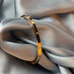 Gold bracelet on a soft gray fabric background