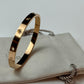 Gold bracelet with small stones on a white surface