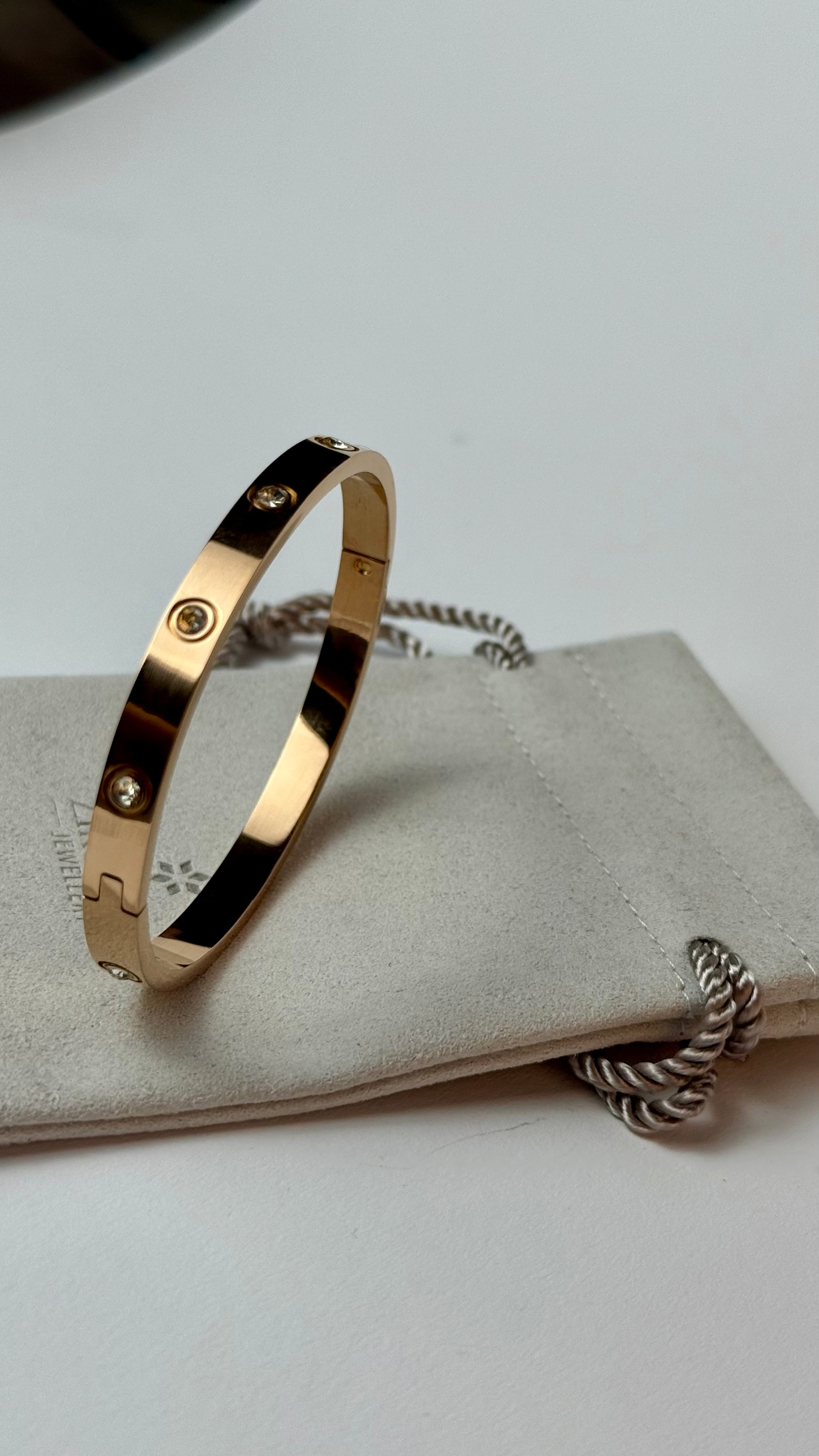 Gold bracelet with small stones on a white surface