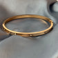 Gold bracelet on a gray fabric surface
