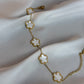 Gold bracelet with floral designs on a white fabric background