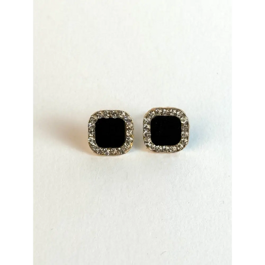 Pair of square black gemstone earrings with silver borders on a white background