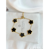 Gold bracelet with black flower-shaped charms on a Zirconiq Jewellery branded card.