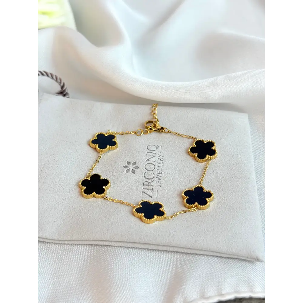 Gold bracelet with black flowers on a Zirconio Jewellers card