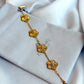 Gold bracelet with floral designs on a Zirconiq branded pouch.