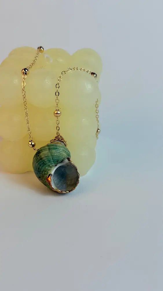 Necklace with a green and gray pendant on a white background