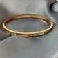 Gold bracelet on a gray fabric surface