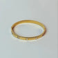Gold ring with small stones on a light gray background